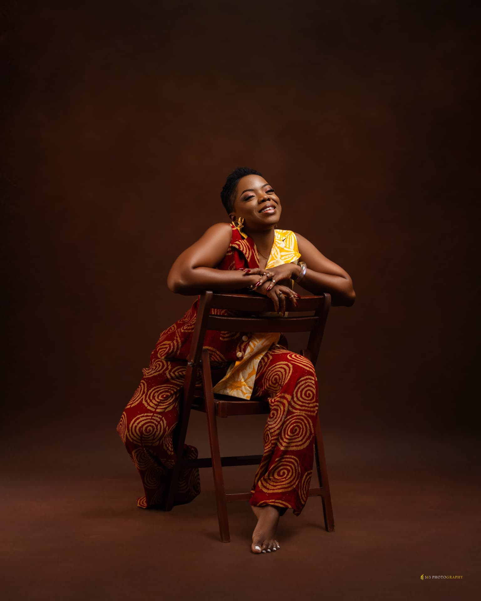 Oluwatosin Abigail Israel seated on a wooden chair, smiling